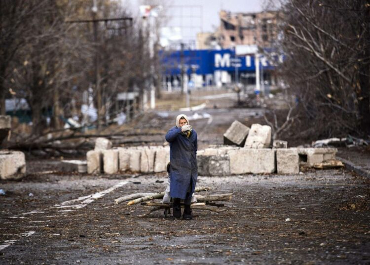Nainen kuljettamassa polttopuita Donetskin lentokentän lähistöllä maanantaina.