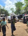 Pakolainen kantaa perheensä ruoka-annosta WFP:n jakelupisteestä suojaansa Balukhalissa Bangladeshissa.