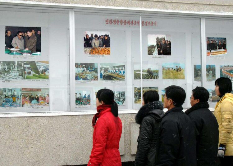 Pohjoiskorealaisia katselemassa kuvia Kim Jong Ilin elämästä keskiviikkona Pjongjangissa.
