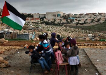 Palestiinalaisia beduiinilapsia taustallaan Maale Adumimin siirtokunta Länsirannalla.