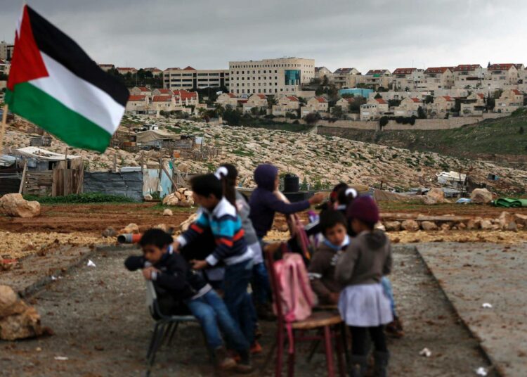 Palestiinalaisia beduiinilapsia taustallaan Maale Adumimin siirtokunta Länsirannalla.