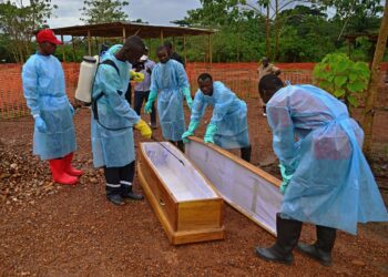Hallituksen työntekijät desinfioivat Ebolan uhrille tarkoitettua arkkua Kailahunissa Sierra Leonessa.