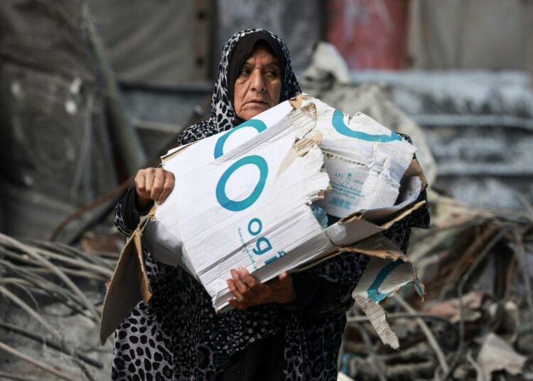 Nainen keräämässä pahvilaatikoita polttoaineeksi Rafahin kaupungissa eteläisessä Gazassa.