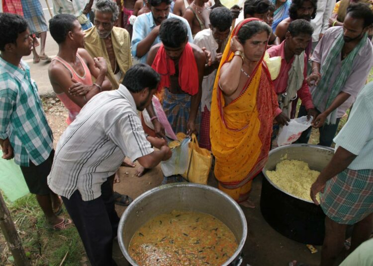 Ruoka-apua jaetaan Intian Odishan osavaltiossa ihmisille, joka menettivät tuhotulvassa kaiken paitsi päällään olleet vaatteet.