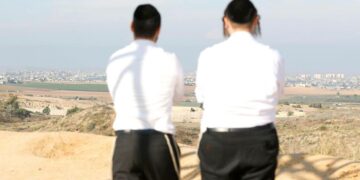 Israelilaismiehiä katsomassa kauempana näkyvää Gazan aluetta kukkulalta Sderotin kaupungista.