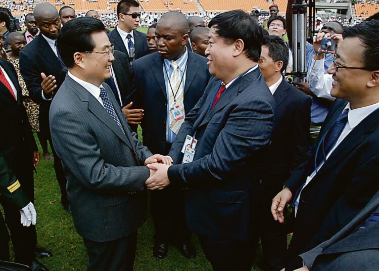 Presidentti Hu Jintao kätteli kiinalaisen rakennusfirman johtajaa Tansanian uuden kansallisstadionin avajaisissa Dar es Salaamissa maaliskuussa. Takavasemmalla Tansanian presidentti Jakaya Kikwete punainen kravatti kaulassaan.