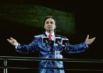 Giorgio Casciarin esittämä Riccardo muistuttaa Naamiohuvien modernissa versiossa pääministeri Silvio Berlusconia.