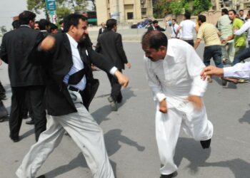 Pakistanilainen lakimies ja entisen vallankaappaajan Pervez Musharrafin kannattaja vaihtavat poliittisia mielipiteitä kadulla Rawalpindissa.