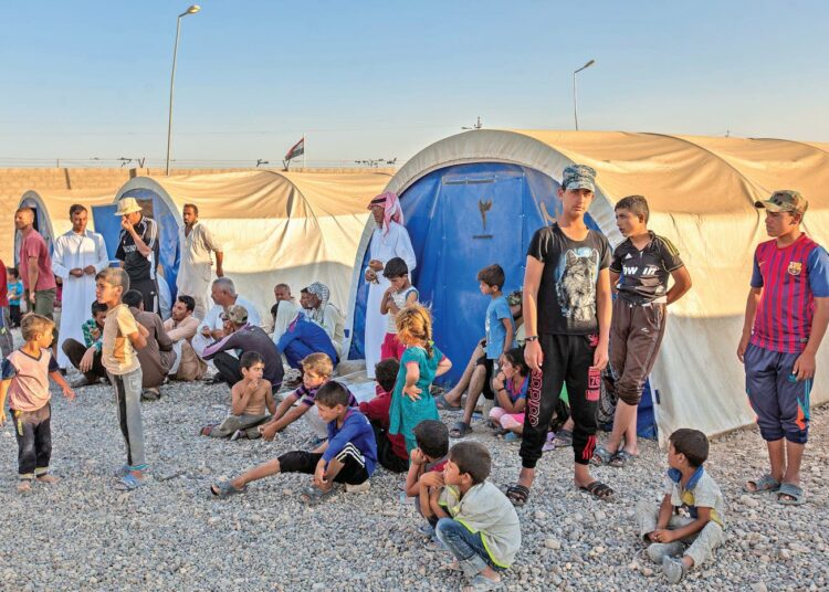 Ryhmä irakilaisia odotti vedenjakelua telttojensa vieressä viime kesäkuussa.
