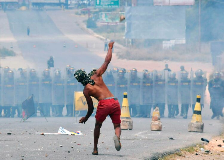 Mielenosoittajat heittivät sunnuntaina kiviä kohti Venezuelan kansalliskaartin sotilaita.
