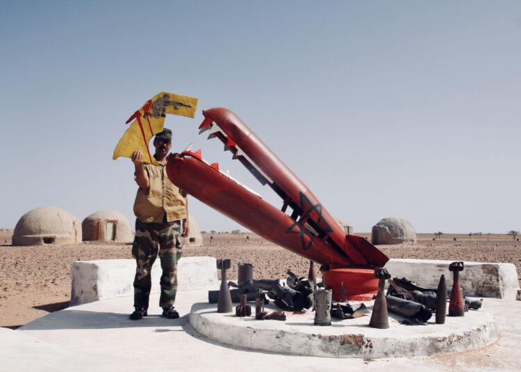Ehmudi Lebsir, pataljoonankomentaja ja Polisarion sotilaskoulun johtaja seisoo Marokon 50 vuotta sitten tapahtuneen Länsi-Saharan valtauksen muistomerkin vieressä.