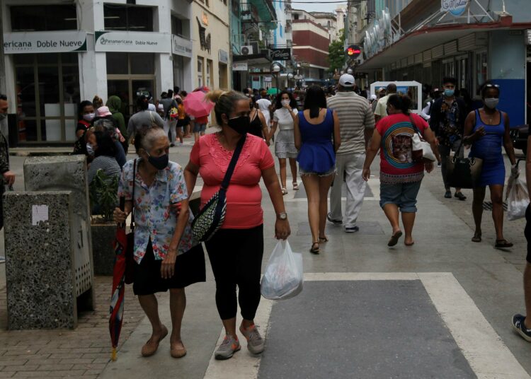 Iäkäs nainen kävelyllä Havannassa, kumppanin tuella. Kuuban hoivan antajista noin kaksi kolmasosaa on naisia, ja heistä useimmat ovat jo viisikymmentä täyttäneitä.