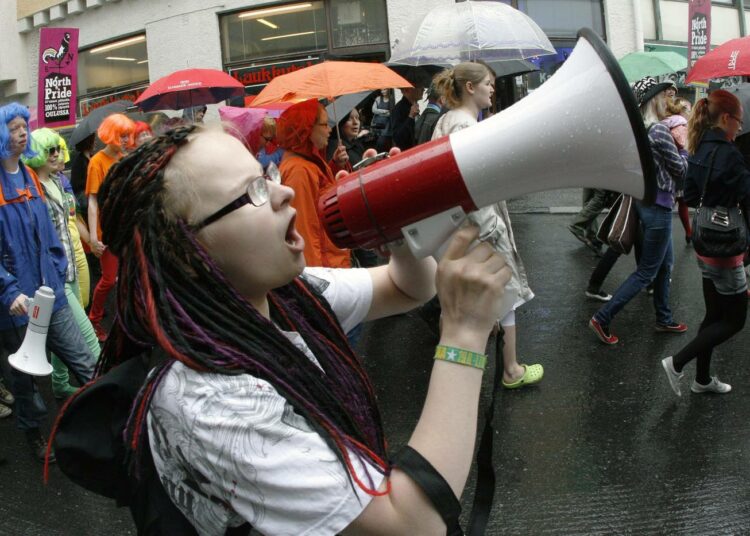 Pride-kulkueen osanottaja huutaa megafoniin kulkueen edetessä sateisessa Oulussa 21. heinäkuuta.