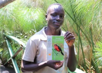 Opas Edgar Ochieng esittelee nuorten ympäristöryhmän kokoamaa käsikirjaa Dunga Beachin linnuista.
