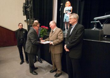 Kansan Uutisten toimitusjohtaja Mikko Pirnes ojentamassa kunniastipendiä Reijo Frankille.