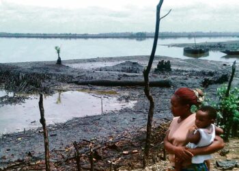 Perheenäiti katseli öljyn tuhoamaa joenpoukamaa Bodossa Nigeriassa. Shell ilmoitti viime viikolla maksavansa 70 miljoonaa euroa vahingonkorvauksia Bodon kyläneuvostolle ja alueen kalastajille.