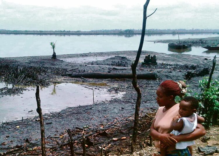 Perheenäiti katseli öljyn tuhoamaa joenpoukamaa Bodossa Nigeriassa. Shell ilmoitti viime viikolla maksavansa 70 miljoonaa euroa vahingonkorvauksia Bodon kyläneuvostolle ja alueen kalastajille.