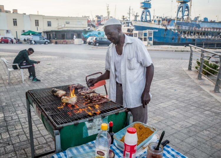 Sudanilaista alkuperää oleva mies valmistaa agashe-vartaita Marsan vastaanottokeskuksen luona.