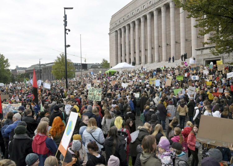 Ilmastolakkoilevat nuoret ja aikuiset täyttivät Eduskuntatalon edustan Helsingin keskustassa perjantaina. Mielenosoittajien määrän vuoksi liikenne Mannerheimintiellä jouduttiin pysäyttämään.
