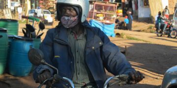 Ugandalainen moottoripyörätaksin kuljettaja odotti asiakkaita maan pääkaupungin Kampalan ulkopuolella elokuussa.
