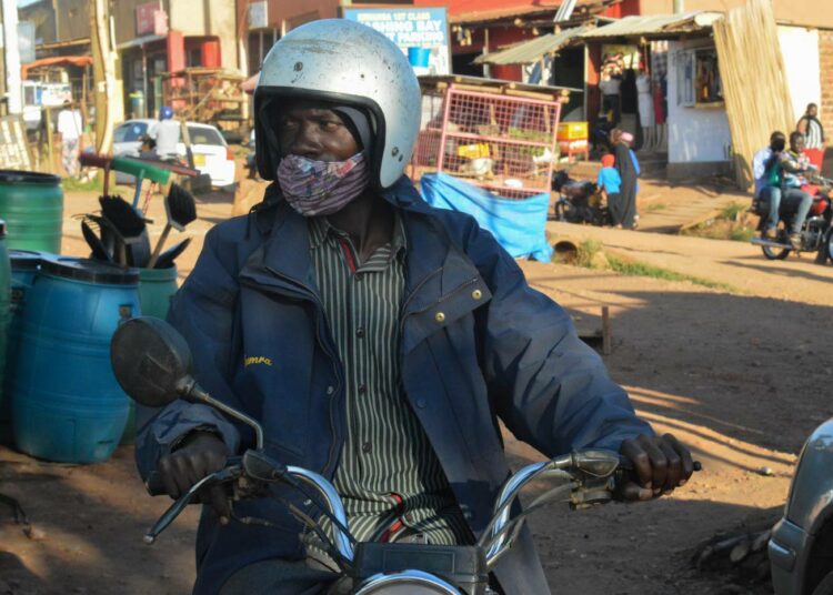 Ugandalainen moottoripyörätaksin kuljettaja odotti asiakkaita maan pääkaupungin Kampalan ulkopuolella elokuussa.