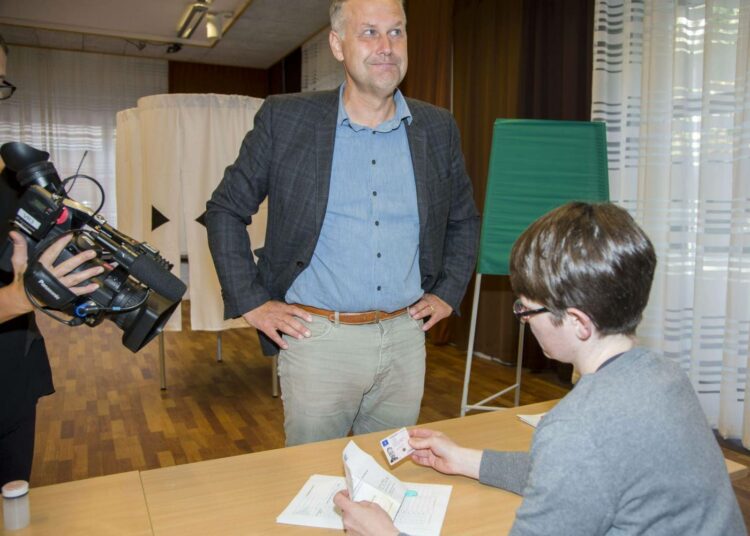 Vaalivirkailija tarkastamassa Vasemmistopuolueen puheenjohtajan Jonas Sjöstedtin henkilöllisyystodistusta vaalipaikalla sunnuntaina Uumajassa.