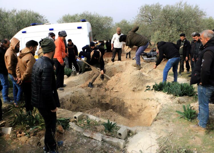 Ystävät ja sukulaiset luovat umpeen koronaan kuolleen Ghada Ismaelin haudan Salqeenin hautausmaalla.