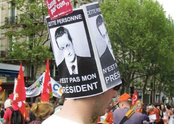 Tämä henkilö ei ole minun presidenttini, lukee vappumielenosoittajan hatussa Sarkozyn kuvan vieressä.