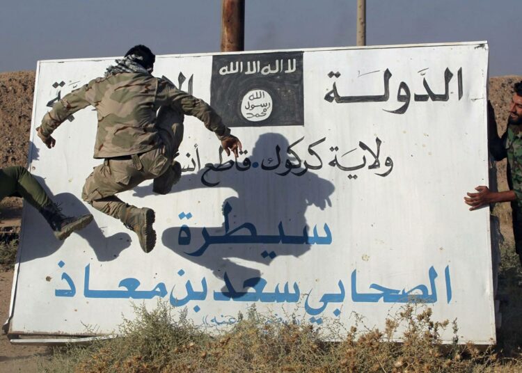Irakilaissotilaat osoittivat vihaansa Isisiä kohtaan potkimalla järjestön julistetta Hawijassa kaupungin takaisinvaltauksen jälkeen lokakuussa.