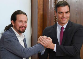 Podemosin Pablo Iglesias ja PSOE:n Pedro Sánchez puristivat kättä sovittuaan koalitiohallituksesta.