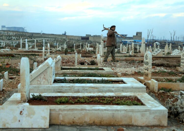 Haudankaivaja Abdul Mohsen Latif Idlibin itäisellä hautausmaalla, jossa hautakivet ulottuvat niin pitkälle kuin silmä kantaa.