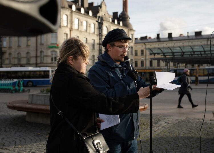 Margarita Khartanovich (vasemmalla) lukee mielenosoituksessa venäläisen oppositiojohtaja Aleksei Navalnyin puhetta. Stefan Smirnov tulkkaa puhetta suomeksi.