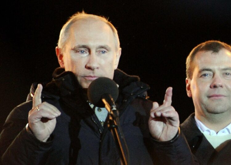 Vladimir Putin liikuttuneena Moskovan Maneesinaukiolla viime sunnuntai-illan voitonjuhlissa. Vieressä väistyvä presidentti Dmitri Medvedev.