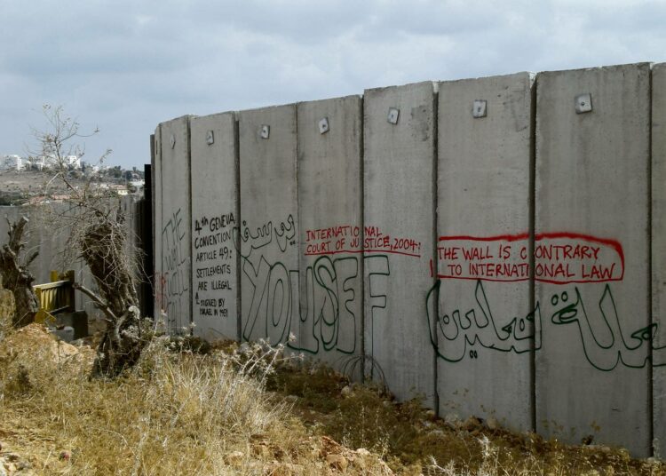 Israelin rakentama muuri Ni’linissä. Piikkilankaesteet sen päältä on revitty alas. Kuva vuodelta 2010.