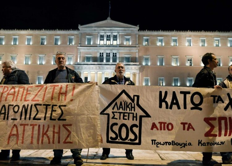 Vasemmistolaiset mielenosoittajat kantavat ”ei taloja pankkiirien käsiin” -banderollia 21 helmikuuta Kreikan parlamentin edessä.