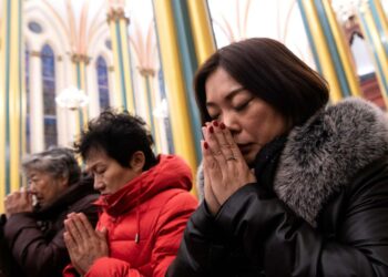 Rukoilijoita jouluyön messussa Pekingissä. Suomalaiset kannattavat koulujen uskonnonopetuksen mullistamista.