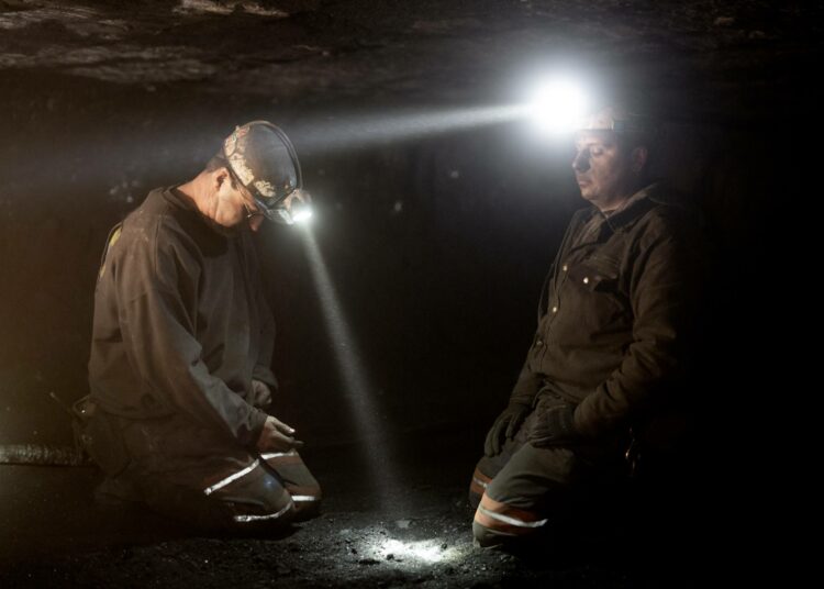 Kaivoksen esimies Chad Riffe ja osaston työnjohtaja Roy Brown EDM No.1 -kaivoksessa. Kaivoksissa työskennellään säkkipimeässä. Ainoat valonlähteet ovat työntekijöiden kypärävalot ja työkoneiden ajovalot. Welch, Länsi-Virginia, tammikuu 2019. Kuva Pirisen Likainen työ -näyttelystä.