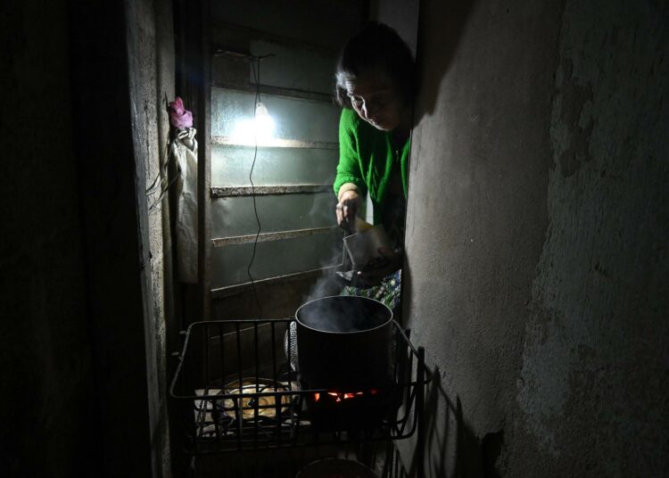 Havannalaisnainen käyttää hiilikeitintä ruoanlaittoon sähkökatkosten aikana. Kuubalaiset kotitaloudet ovat palanneet polttopuun ja hiilen käyttöön, myös kaupungeissa.