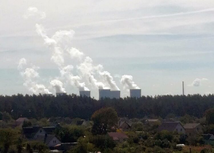 Varašissa sijaitsevan Rivnen alueen ydinvoimalan jäähdytystorneista kohoaa vesihöyryä ukrainalaisen kylämaiseman horisonttiin.