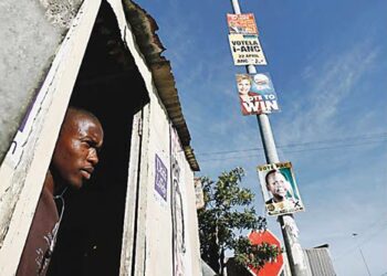 Parturi Mbukushe Bongile katseli ulos peltihökkelistään Khayelitsassa mustien asuma-alueella Kapkaupungin lähellä.