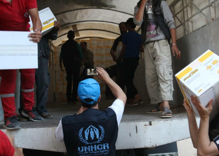 YK:n avustustyöntekijä seuraa avustusrekan purkamista Damaskoksessa, Syyriassa.