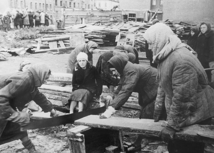 Piiritetyssä Lenin-gradissa oli pulaa kaikesta.Kuvassa kaupunkilaiset sahaavat polttopuita.