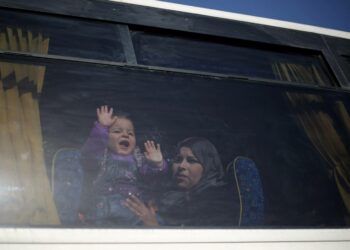 Palestiinalaisnainen lapsineen odottamassa lupaa rajan ylittämiseen Gazasta Egyptiin Rafahin raja-asemalla maaliskuussa.
