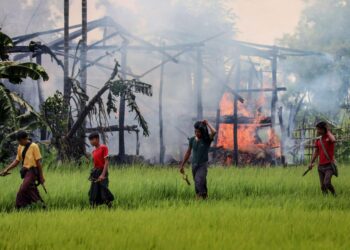 Syyskuussa Gawdu Tharyan kylässä Myanmarin Rakhinen osavaltiossa otetussa kuvassa näkyy veitsin ja lingoin aseistautunut miesjoukko.