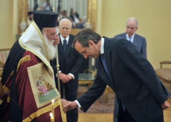 Tuore pääministeri Antonis Samaras kumarsi Kreikan arkkipiispan Ieronimosin edessä keskiviikkona Ateenassa. Oikeiston Uuden demokratien lisäksi hallitukseen kuuluvat sosialidemokraattinen Pasok ja pieni vasemmistopuolue Dimar.