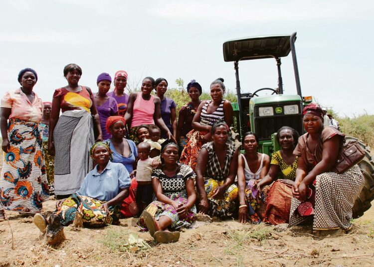 Chibombon piirikunnassa sijaitsevan kylän naiset yhteiskuvassa traktorin kanssa, joka on saatu kylään osittain suomalaisen kehitysyhteistyöprojektin kautta.
