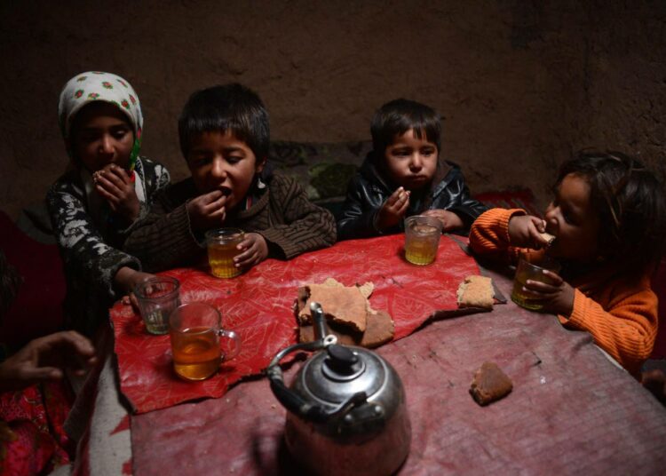 Afganistanilaislapsia lämmittelemässä lieden ääressä Heratissa.