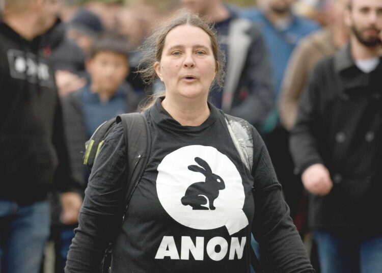 QAnon-paitaan pukeutunut nainen osoitti mieltään rokotuksia ja koronavirukseen liittyviä rajoituksia vastaan Liverpoolissa Englannissa marraskuun puolivälissä.