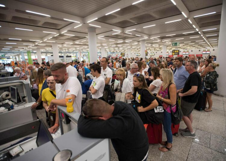 Thomas Cook -yhtiön asiakkaita odottamassa tietoa kotiinpaluusta maanantaina Palma de Mallorcan lentokentällä Espanjassa.