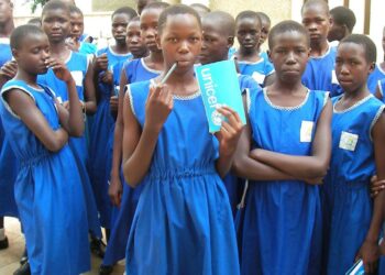 Ugandalaisia koulutyttöjä Unicefin lahjoittamine koulupukuineen.